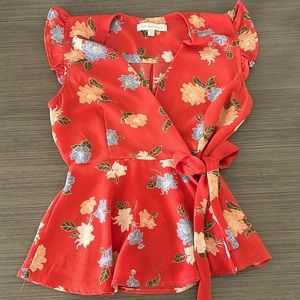 Red flowered Blouse with bow detail on the side.